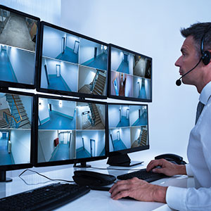 Security operator using TEKWave remote guarding system to monitor community cameras.